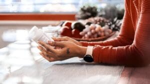 Woman holding a bottle of Lysine for Immune Health.
